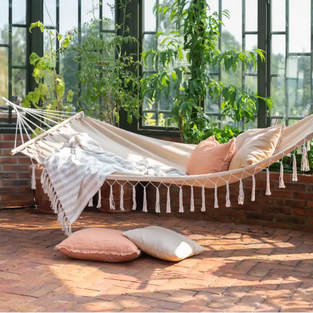 Beige hängmatta med dekorativa fransar, visad mot vit bakgrund.