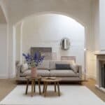 Zuiver Blossom 3-sits soffa i sandfärgat tyg med valnötsram – Japandi-stil i ljust rum med spegel och konst.