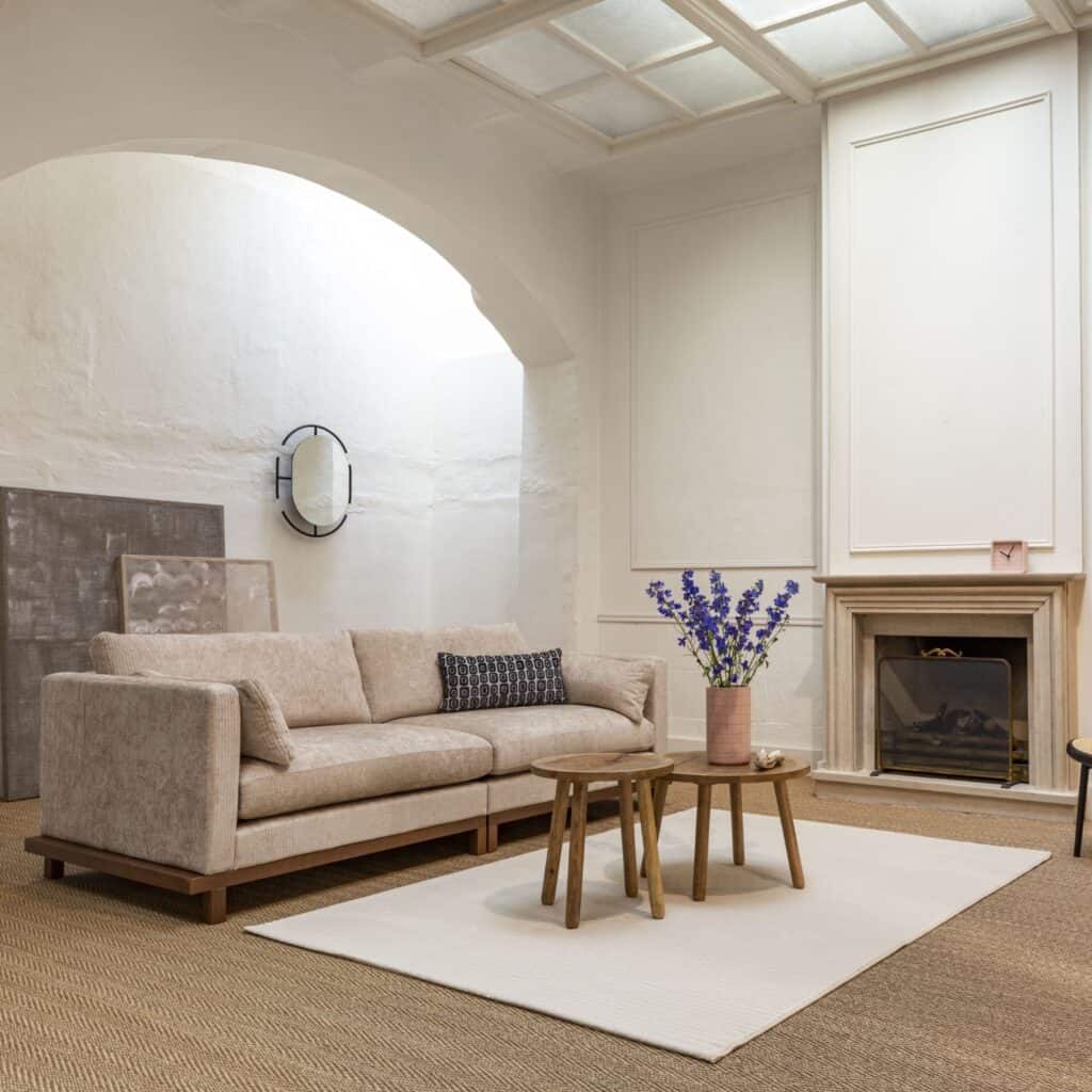 Zuiver Blossom 3-sits sandfärgad soffa med träsockel i valnöt – stilren Japandi-inredning med öppen spis.