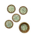 Fem glasunderlägg med grön snäckdesign och flätad kant i rotting