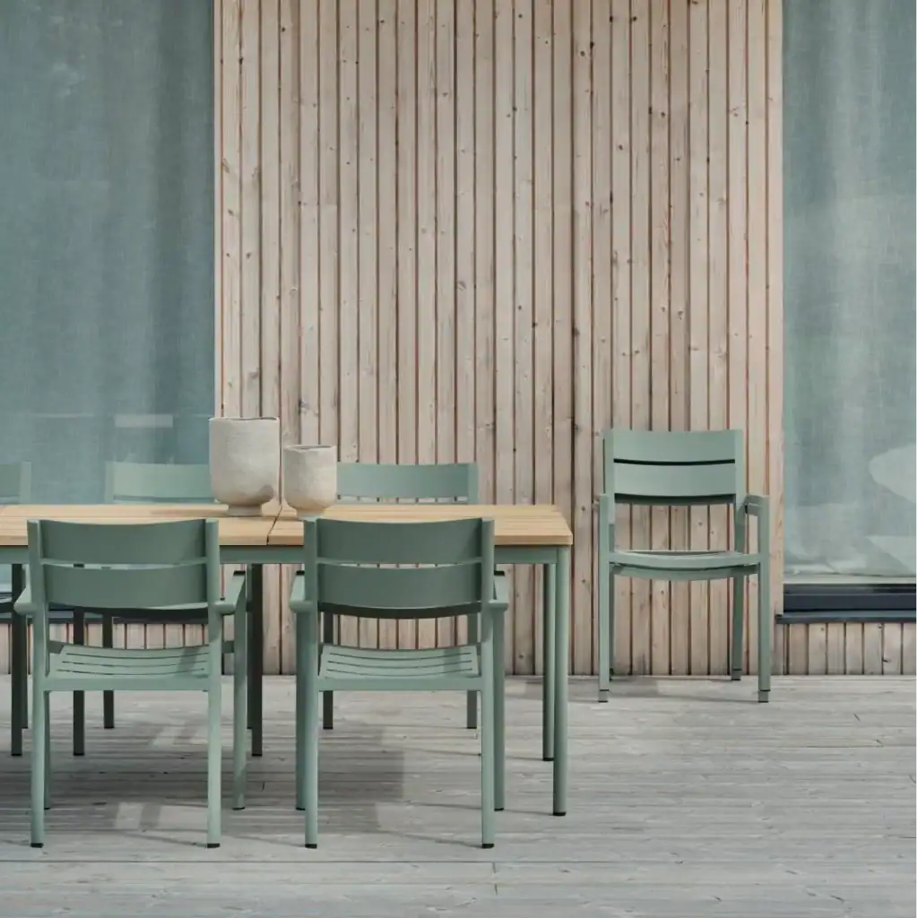 DELIA karmstolar runt ett matbord på altan med trädpanel i bakgrunden.