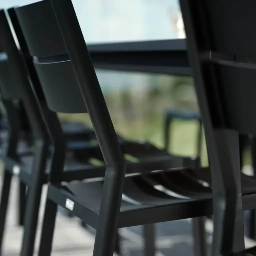 DELIA matstolar i svart under ett bord, sedd från sidan