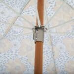 Undersida av Gatsby parasoll blommig 185 cm från Brafab med trästång i bok, beslag i borstad zink och blommigt tyg i gult och vitt.