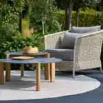 Fåtölj beige Brafab Aster på altan med grönt trädgårdslandskap i bakgrunden