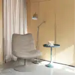 Golvlampa READER i krom från Zuiver placerad bredvid en beige fåtölj i ett modernt vardagsrum.