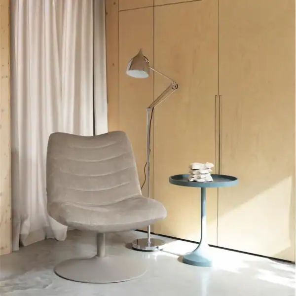 Golvlampa READER i krom från Zuiver placerad bredvid en beige fåtölj i ett modernt vardagsrum.
