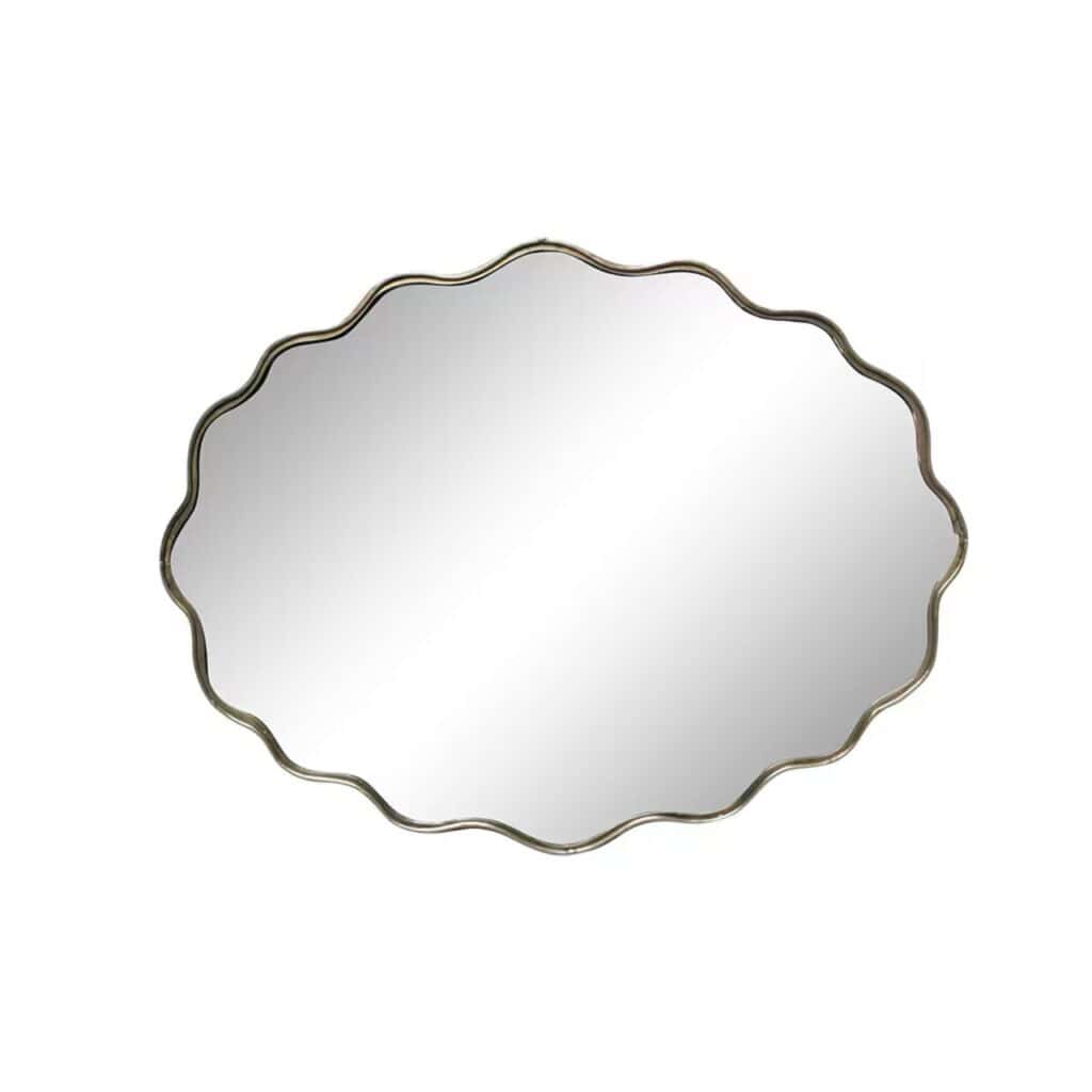 Liggande oval spegel med vågig kant i antik mässing från Strömshaga, modell Jonna, frilagd mot vit bakgrund.