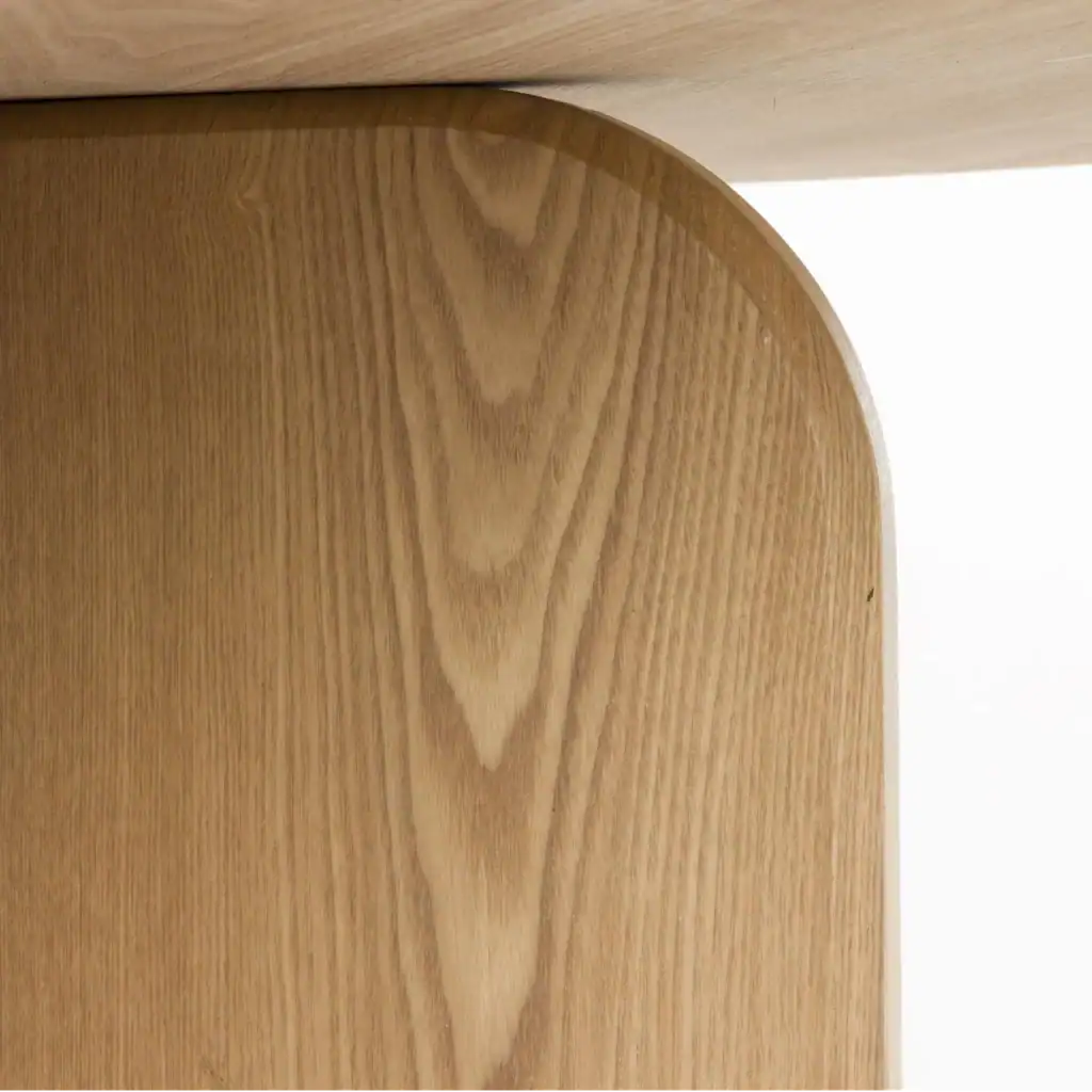 Matbord Laurent i naturfärg, sedd från sidan med en tydlig vy över den stilrena bordsskivan och den stabila korsformade basen.