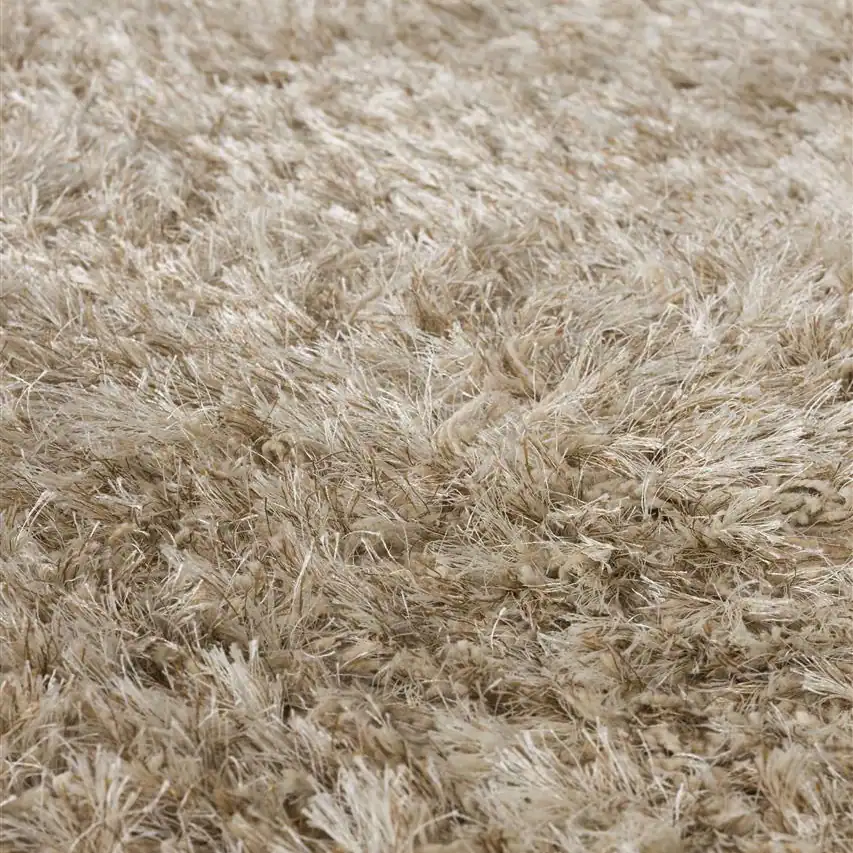Närbild på den mjuka luggen på matta HAIRY i beige från Zuiver, som visar dess textur och täthet.