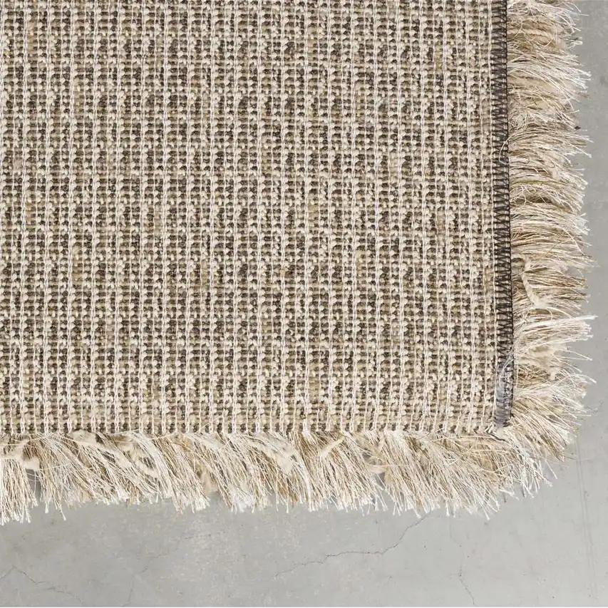Baksidan av matta HAIRY i beige från Zuiver med flätad väv och dekorativa fransar.