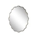 Oval spegel med vågig kant och ram i antik mässing från Strömshaga, modell Jonna, mot vit bakgrund.