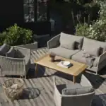Trädgårdssoffa ASTER beige i loungemiljö på träaltan tillsammans med fåtöljer och bord