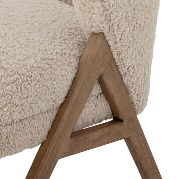 Närbild på Camino fåtölj från Bloomingville i beige teddyklädsel med ben i mörk rubberwood.