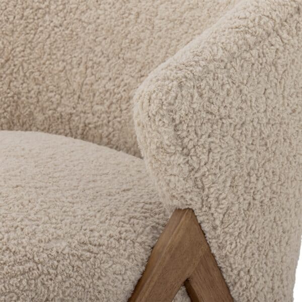 Närbild på Camino fåtölj i beige teddyklädsel från Bloomingville med ben i mörk rubberwood.