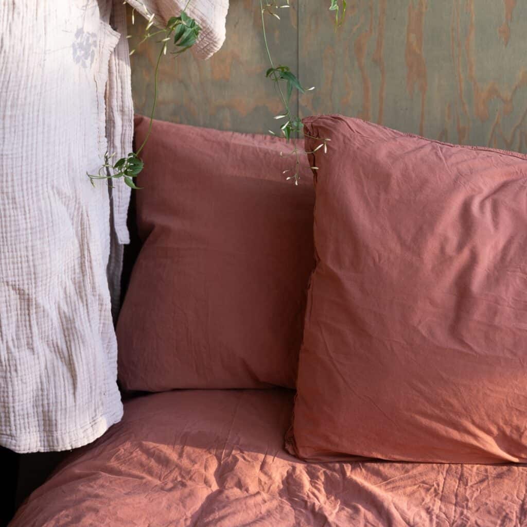 Örngott och påslakan i ekologisk bomull Terracotta på bäddad säng med mjuka texturer