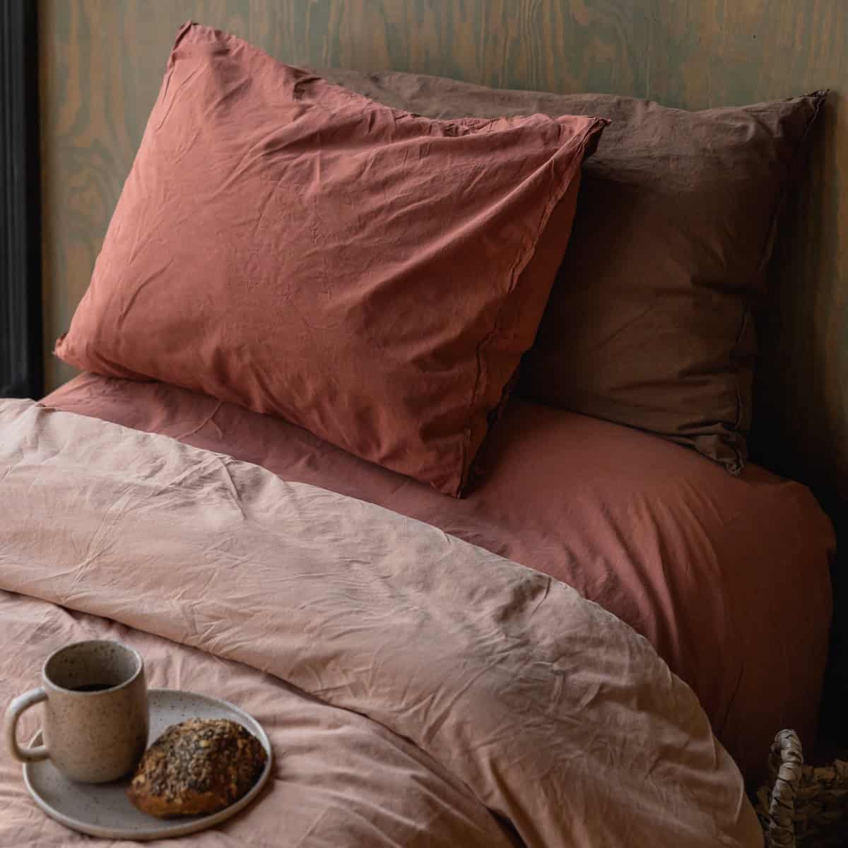 Påslakanset ekologisk bomull Terracotta på bäddad säng med matchande örngott och frukostbricka