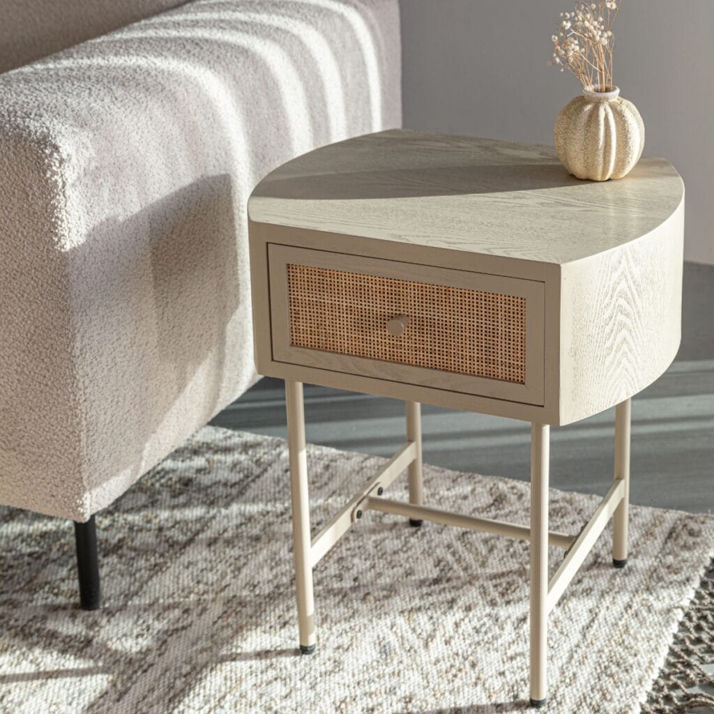 Sängbord AMAYA beige från Hemlängtan, nattduksbord med rottingfront placerat bredvid soffa i modern inredning.