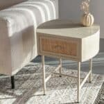 Sängbord AMAYA beige från Hemlängtan, nattduksbord med rottingfront placerat bredvid soffa i modern inredning.