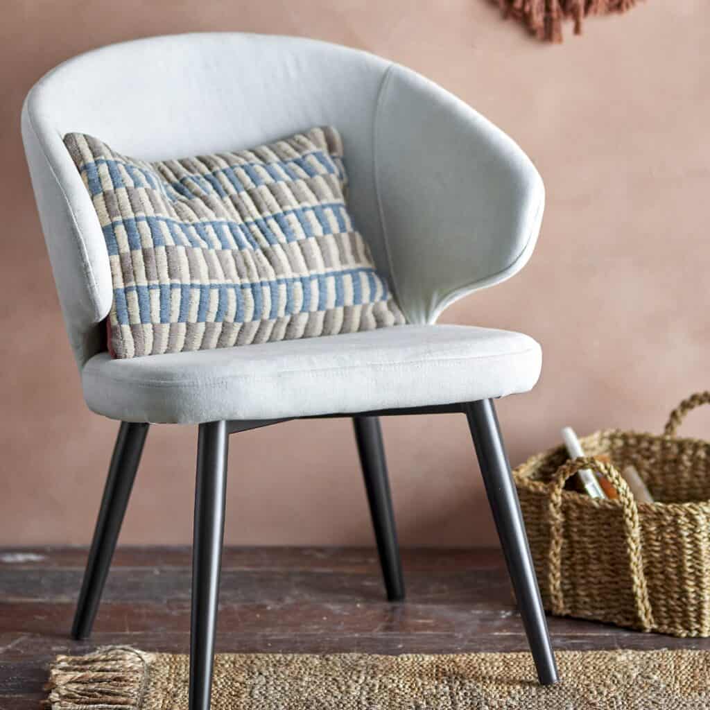 Stol Loon Beige Bloomingville – lounge-stol i beige tyg med svarta metallben, stylad med kudde och korg i en varm inredningsmiljö.