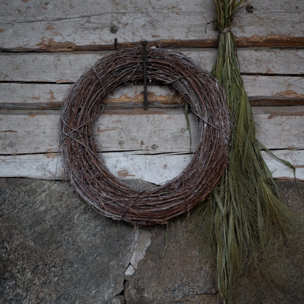 Kransstomme i naturmaterial 30 cm från Wikholm Form upphängd på vägg i rustik miljö