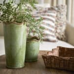 Bricka COLLECT i naturfärgad rotting från Affari of Sweden – miljöbild på soffbord med gröna vaser.