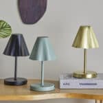 Tre laddningsbara bordslampor från Bloomingville – Lianna i svart, grön och mässing på ett träbord.