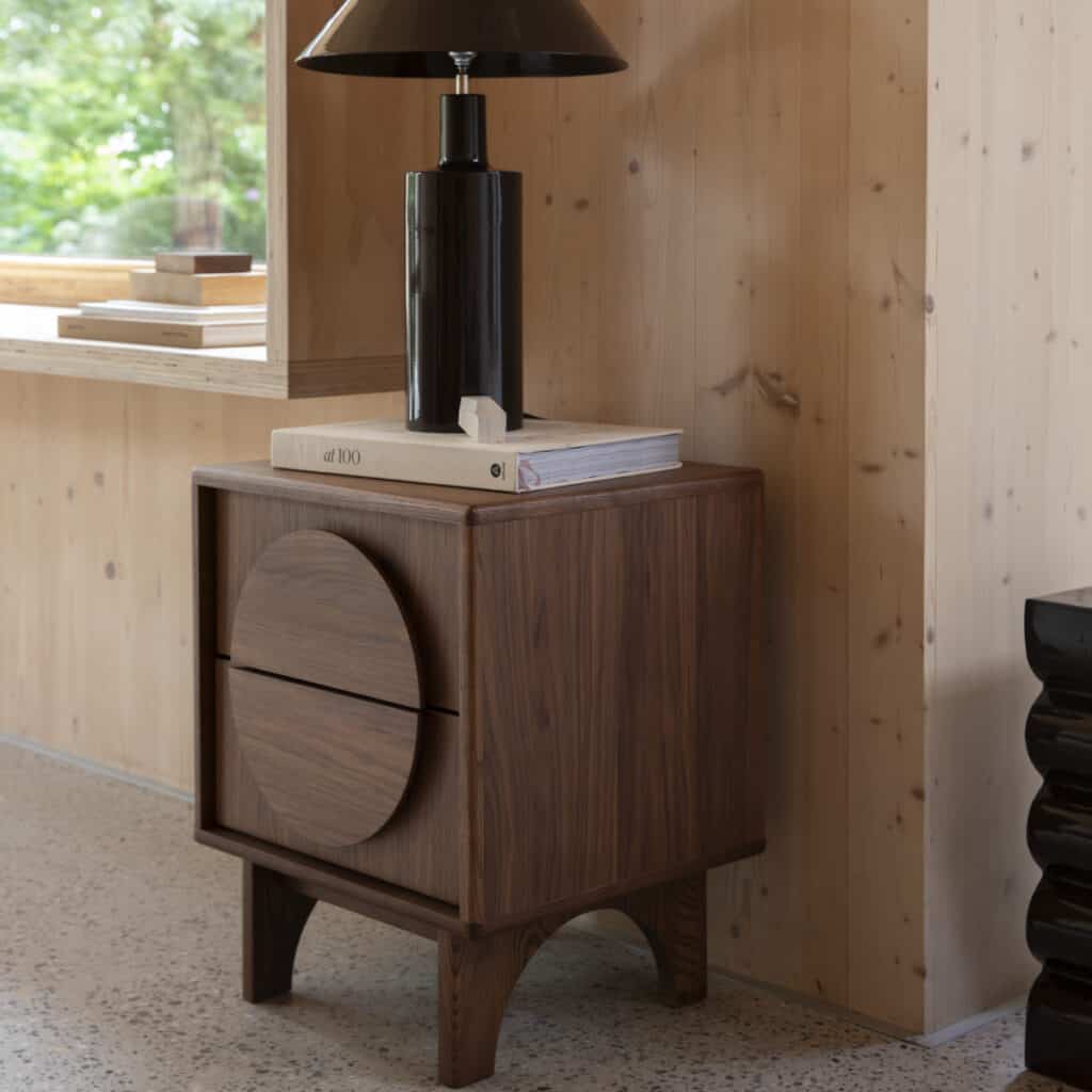 Sängbord Groove från Zuiver i valnötsfanér – stilren design i naturlig trämiljö med bordslampa och böcker.