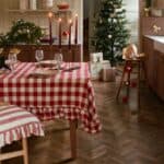 Juldukning med rödvit rutig duk i ekologisk bomull, Duk Ida Ruta från Strömshaga, i varmt och hemtrevligt kök med gran och levande ljus.