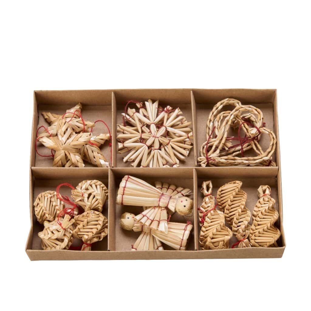 Ask med tolv halmdekorationer till jul – mix av hjärtan, stjärnor, änglar och granar i naturfärgad halm.