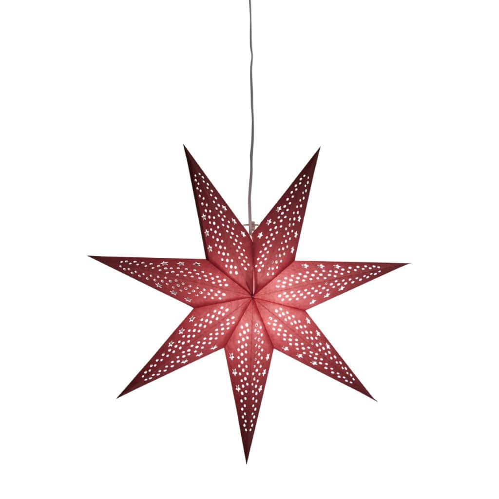 Röd julstjärna i papper med hålmönster, tänd och sprider varmt ljus – UNI från Hemlängtan.