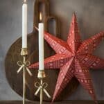 Miljöbild med röd julstjärna UNI och mässingsljusstakar – julstämning från Affari of Sweden.