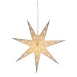 Vit julstjärna UNI i papper, tänd och hängande i fönster med varmt sken.