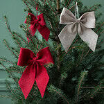 Röda rosetter i granen – juldekoration i textil från Hemlängtan.