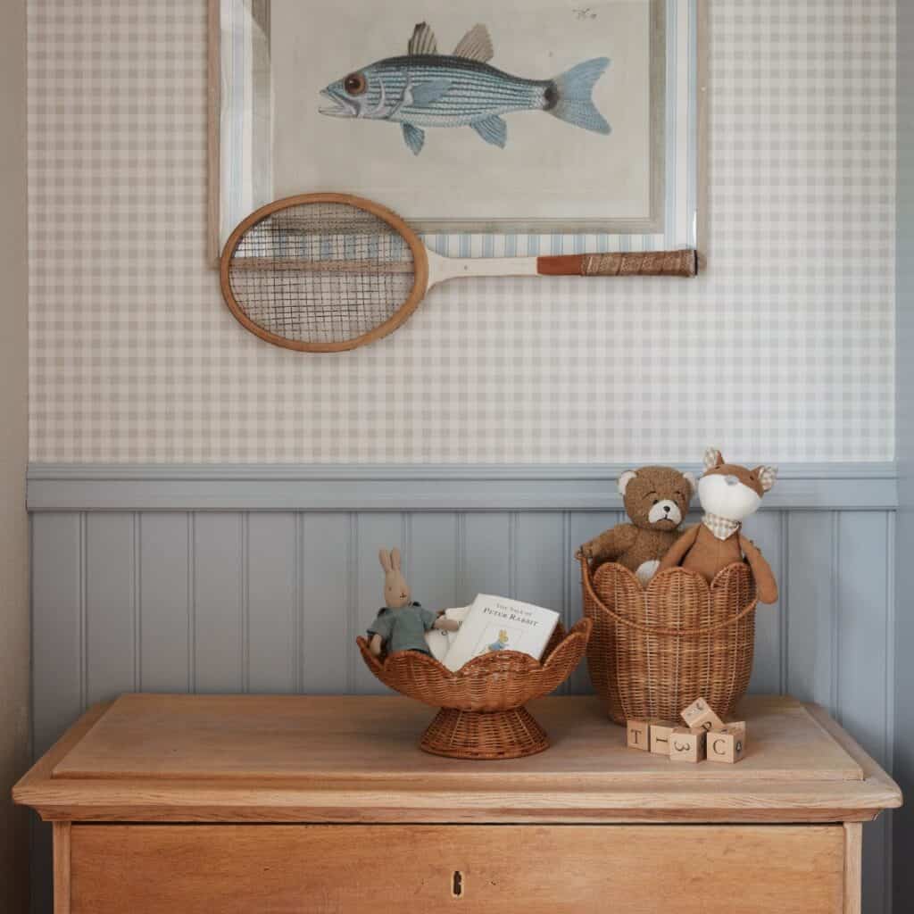 Fruktskål i naturfärgad rotting på fot använd som förvaring på byrå i barnrum