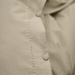 Närbild av påslakanset MARABEL i beige med tygknappar och broderad söm