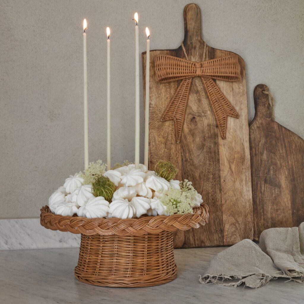 Rosett i rotting som dekoration på träbräda tillsammans med ljus och stilleben