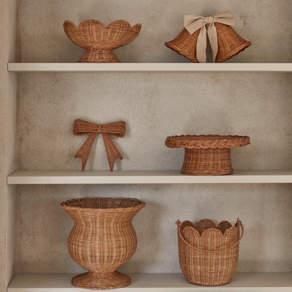 Rottinginredning med korgar, rosett och dekorationer på hylla