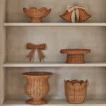 Rottinginredning med korgar, rosett och dekorationer på hylla