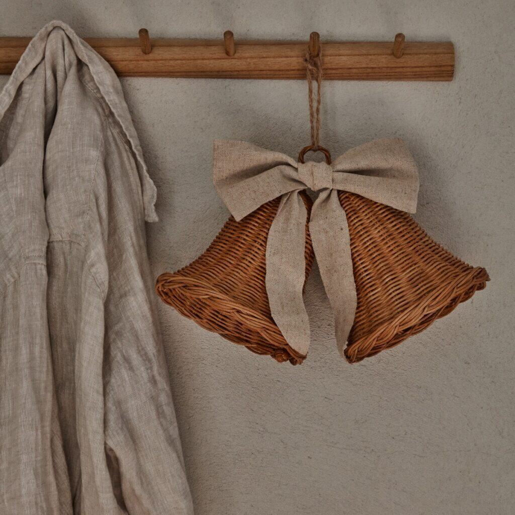 Rottingklockor med linneband hängande på träkrok i hallmiljö