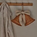 Rottingklockor med linneband hängande på träkrok i hallmiljö