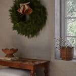 Handgjord korg i naturfärgad rotting med vågig kant placerad på fönsterbräda i lugn, tidlös inredningsmiljö.