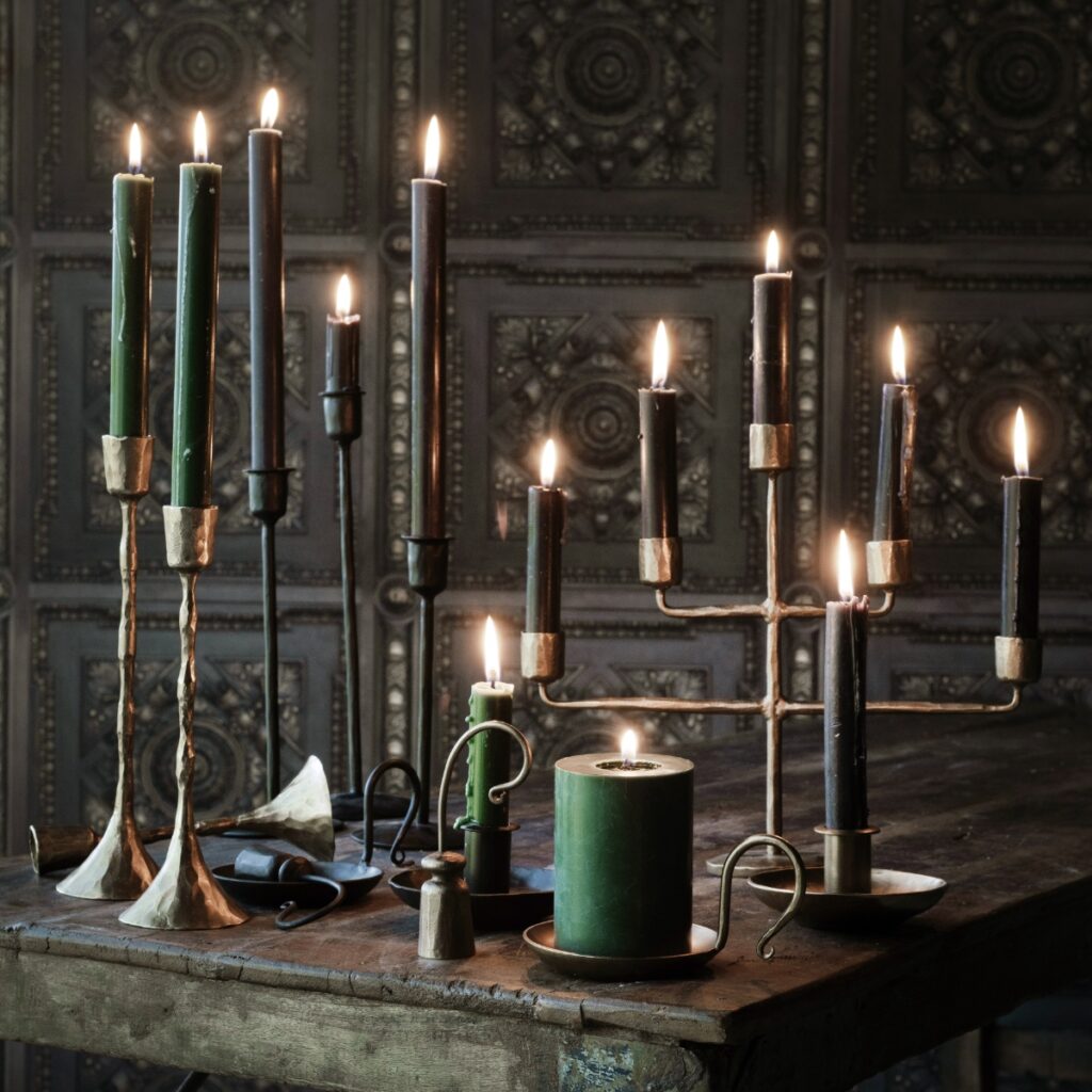 Anjali ljusstakar i antik guld med tända kronljus på rustikt bord