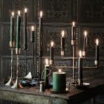 Anjali ljusstakar i antik guld med tända kronljus på rustikt bord