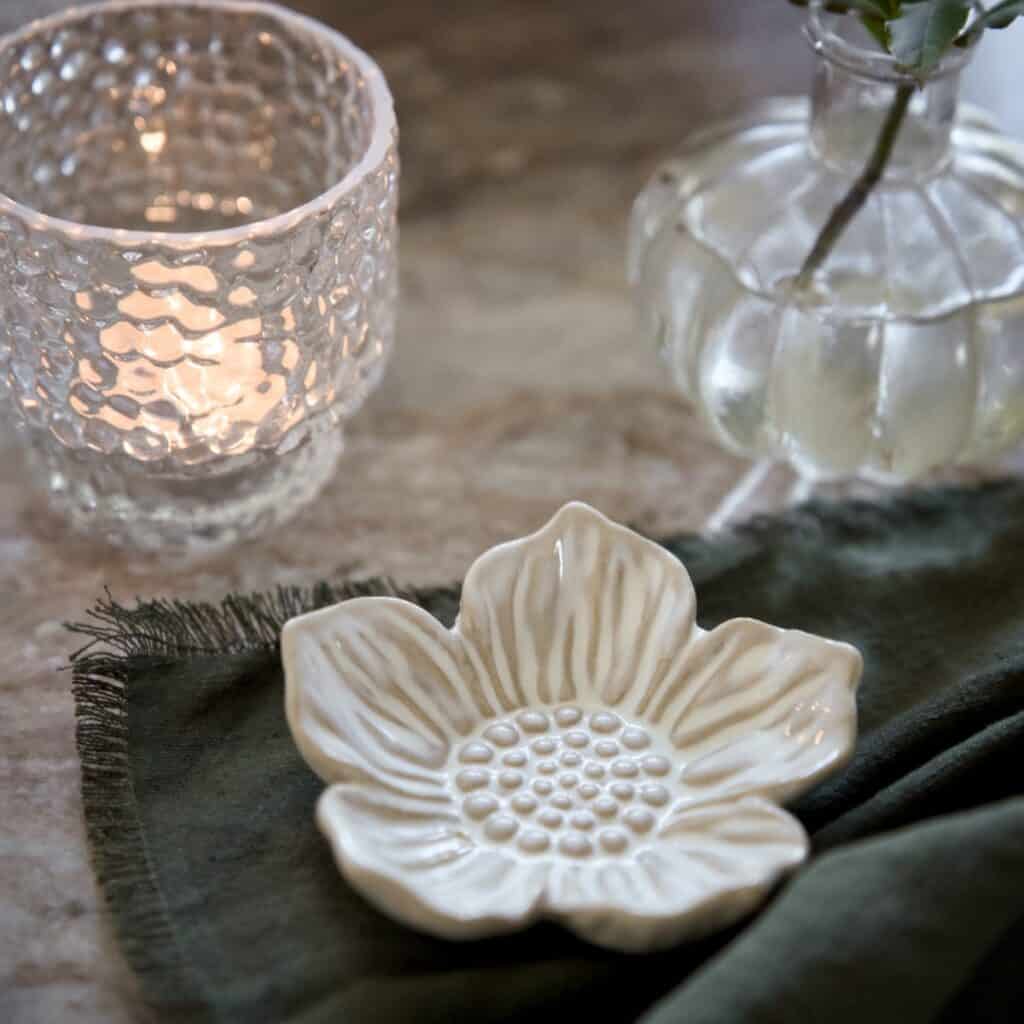 Dekorationsfat Ingrid i offwhite porslin på duk med tänt ljus och glasvas