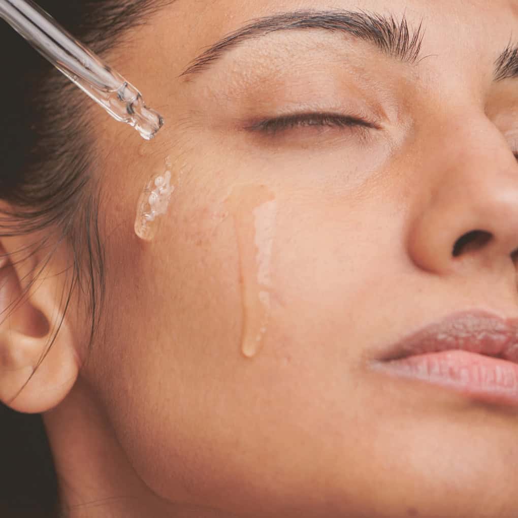 Ekologisk rosmarinolja appliceras på ansiktshud med pipett