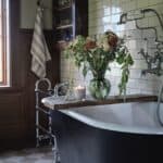 Doftljus i beige glas av sojavax placerat i mysig hemmiljö med varm belysning