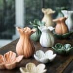 Persikorosa Ingrid vas i porslin på träbord tillsammans med vaser i flera färger