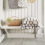 Picknickkorg MOLLY i naturfärgad pil med grön insida placerad på bänk i ljus hallmiljö