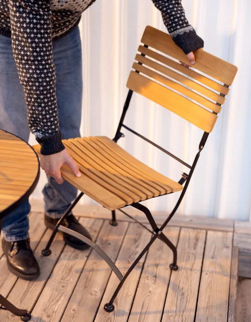 Hopfällbar trästol på balkong – perfekt för liten yta