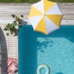 Randigt parasoll Valletta i vitt och gult vid pool